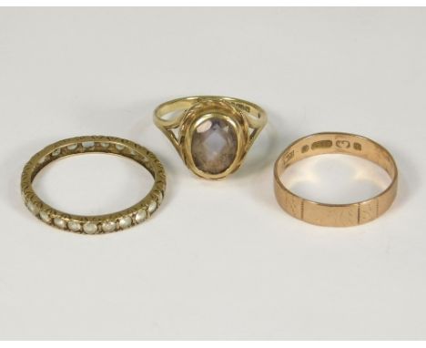 GOLD RINGS. A 9ct. gold wedding band, a 9ct. gold amethyst dress ring &amp; a paste set eternity ring.