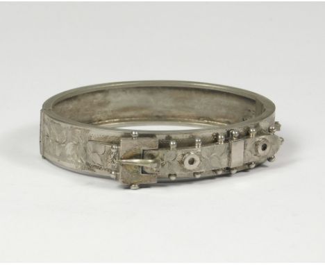 HINGED BANGLE. A 19th century strap &amp; buckle hinged bangle.