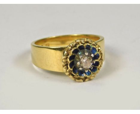 GOLD RING. An 18ct. gold ring set a solitaire diamond within a blue enamelled flowerhead setting. (Adapted) Size K.