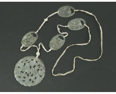 JADE NECKLACE. A jade necklace, the pendant drop pierced & carved with exotic birds, the other plaques similarly carved. The 