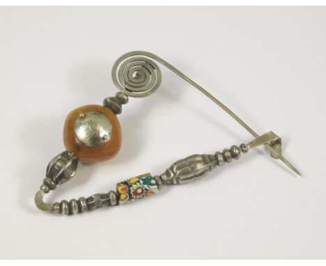 SILVER PIN. A large hand made silver shawl or cloak pin, featuring a millefiori trade bead & a silver mounted antique amber b