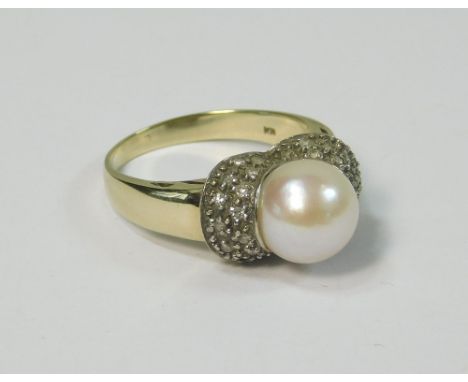 PEARL RING. A 9k. cultured pearl dress ring, the pearl within a diamond set mount. Size L. Approx. 4.1g.