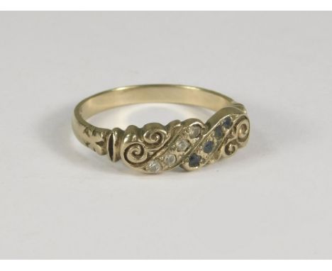 GOLD RING. A 9ct. gold ring set with two diagonal rows of stones, one diamonds, the other sapphires. Size N.