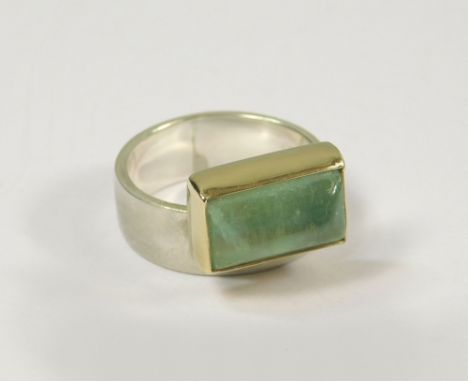 HAND MADE RING. A silver &amp; yellow metal hand made ring, set a polished pale green stone. Size N.