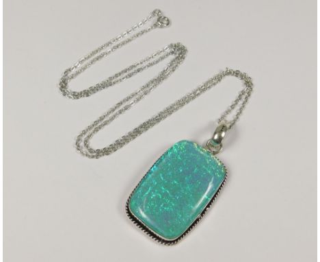 SILVER PENDANT. A large silver mounted opal doublet pendant with chain.