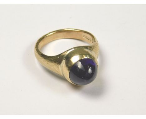 GOLD RING. A 9ct. gold hand made dress ring set a cabouchon amethyst by John (Red) Simpson, St. Ives. Size M. Approx. 6.4g.