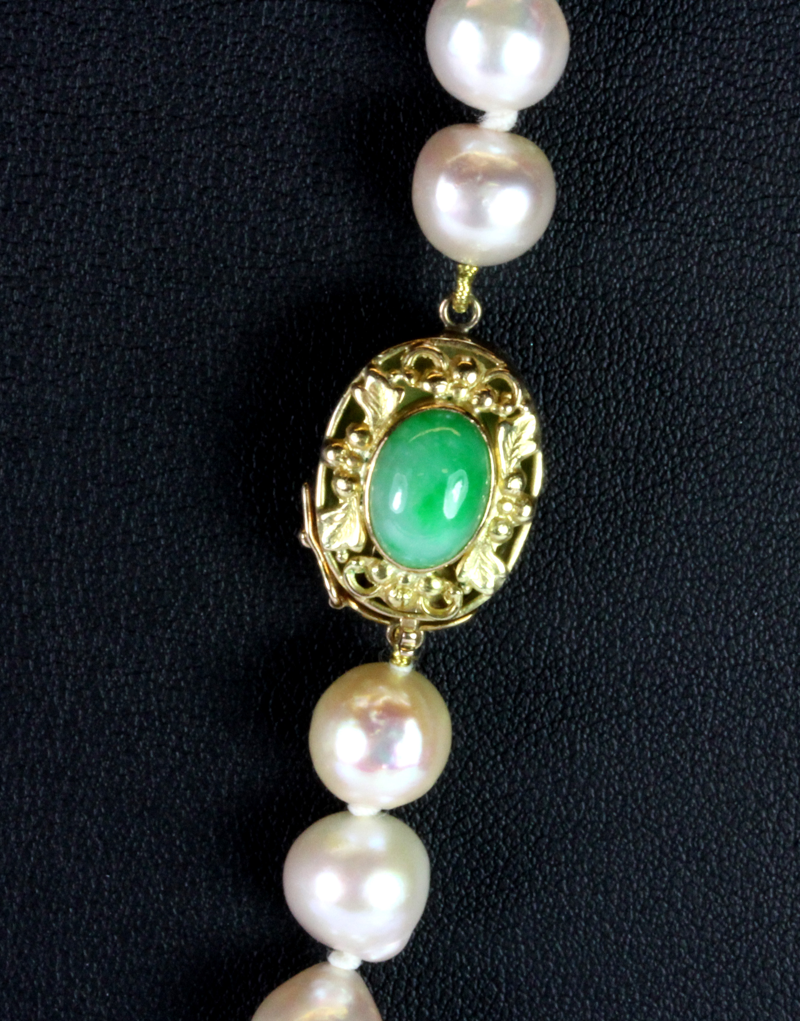 A lovely cultured pearl necklace on a 14ct yellow gold jade set clasp.