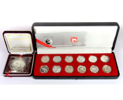 A cased set of twelve Chinese silver year sign coins with a further cased silver coin.