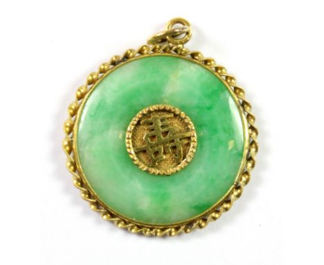 A yellow metal (tested 18ct gold) jade set pendant, Dia. 3cm.