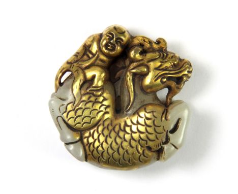A 19th/20th century Chinese gilt jade amulet of a boy riding a dragon, D. 5cms. Depth. 2cms.