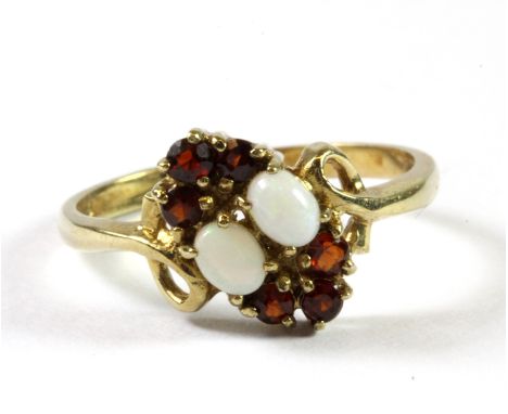 A 9ct yellow gold opal and garnet ring (O).