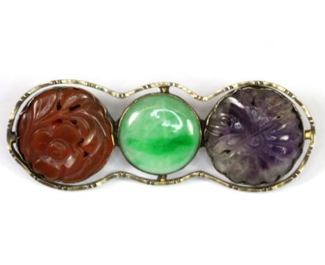 An interesting white metal (tested silver) brooch set with Chinese carved cornelian, amethyst and jade, L. 5.6cm.