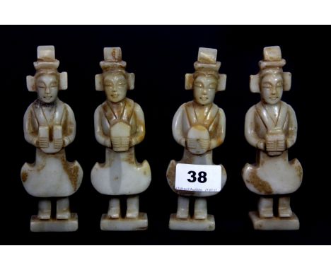 A set of four Chinese carved celadon nephrite jade figures of Mandarins, H. 15cms.