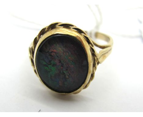 A 9ct Gold Black Opal Doublet Single Stone Ring, oval collet set between pierced shoulders (finger size O) (2.5grams). 