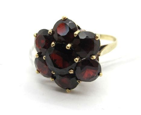 A Large 9ct Gold Garnet Cluster Dress Ring, of flowerhead design, claw set (finger size N) (3.2grams). Lot 277 - The ring is 