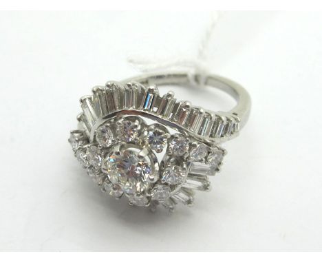 A Large Diamond Set Cocktail Dress Ring, of fancy crossover design, claw set throughout with brilliant and baguette cut stone