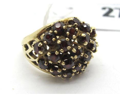 A Garnet Set Dress Ring, of bombé style, claw set throughout between pierced shoulders, stamped "9ct" (finger size O) (7.5gra