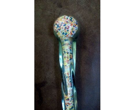 A twisted glass walking stick molded around what can be described as hundreds and thousands