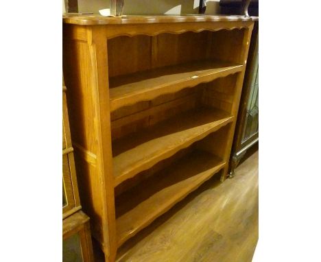 French light oak open bookcase of three shelves raised on shaped front supportsMeasures 49in high x 50in wide x 14in deep 