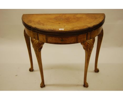 Good quality figured walnut card table, circa 1930, the shaped moulded top above a serpentine shaped frieze and shell carved 