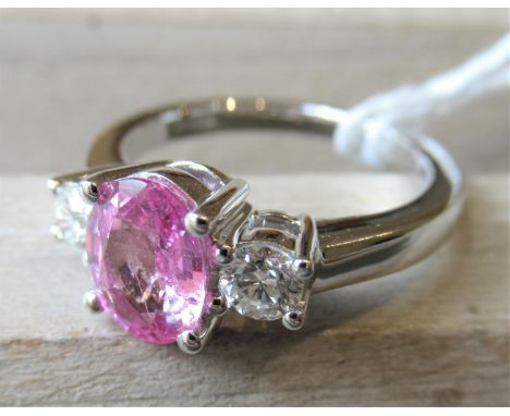 18ct White gold three stone ring set oval pink sapphire flanked by two diamonds, the sapphire approximately 1.50ctRing Size L