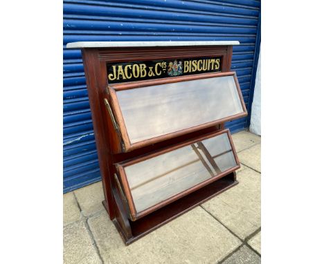 A Jacob &amp; Co'.s Biscuits two tier mahogany serving cabinet, the two tiers with glass fronts and brass fittings, all below