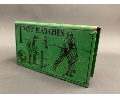 A rare green enamel matchbox holder, decorated with a cricketing scene, and bearing the words 'The Best Test Match', 4 3/4" w