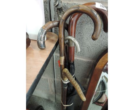 A bundle of vintage decorative walking canes, riding crop and umbrella including white metal cast racoon and snake handle, HM