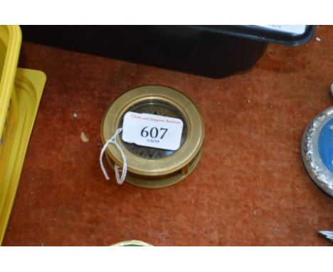 A reproduction brass compass (98)