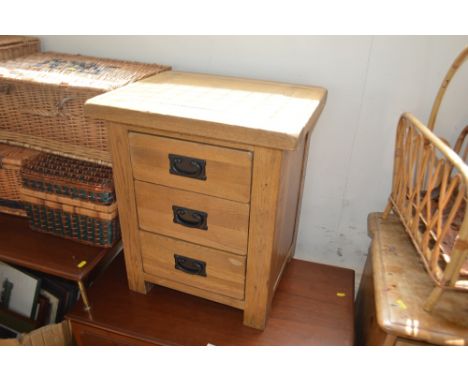 A light oak three drawer bedside chest