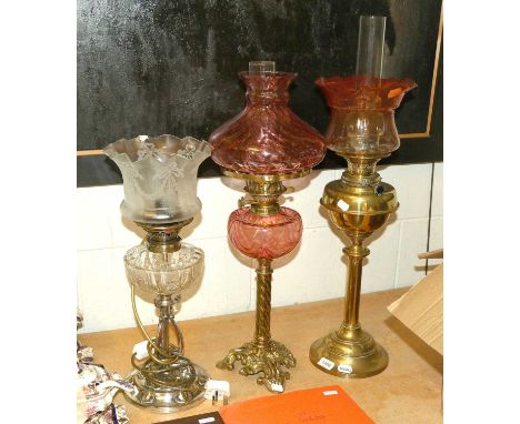An Art Nouveau Oil Lamp, with silver plated base, cut glass reservoir and etched shade, a brass based oil lamp with cranberry