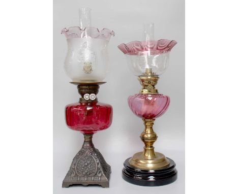 A Victorian Brass-Based Oil Lamp, with cranberry glass reservoir and glass shade with trailed decoration, together with anoth