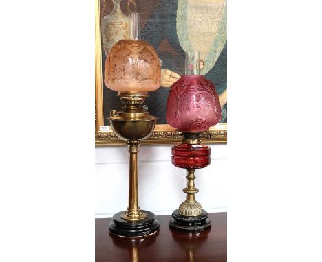 A Victorian Brass-Based Oil Lamp, with cranberry reservoir and shade, together with another oil lamp (2)Peach shade with chip