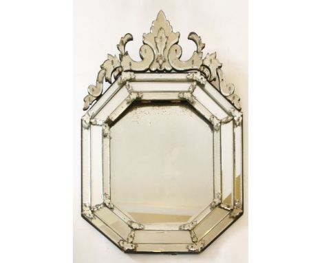 A Venetian glass wall mirror,19th century, with a decorative applied floral and leaf scrolled finial above a three-banded oct