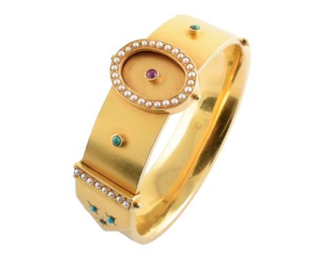 A Victorian design 18ct gold bangle set with seed pearl, turquoise sapphire and ruby, circa 1890, the satin finished hinged b