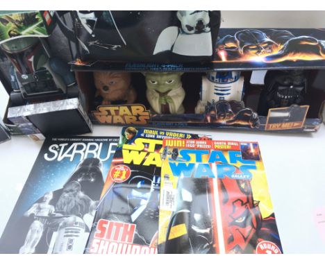 A Collection of Star Wars Merchandise in clouding Comics. Flashlights. A Wallet. Belt and a Bobba Fett Lego Alarm Clock.
