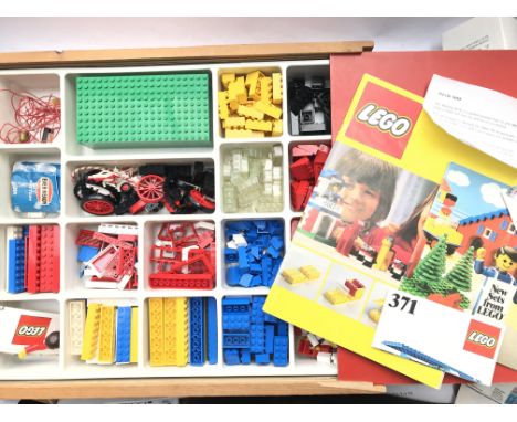 A Box Containing a Collection of Lego and includes a Lego Guide Book.