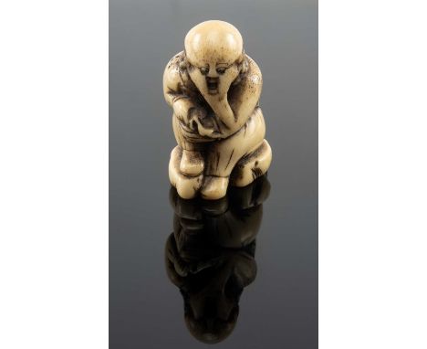 JAPANESE STAG ANTLER NETSUKE, Edo Period, stained and carved as a seated Sage holding his knee, single himotoshiProvenance: p