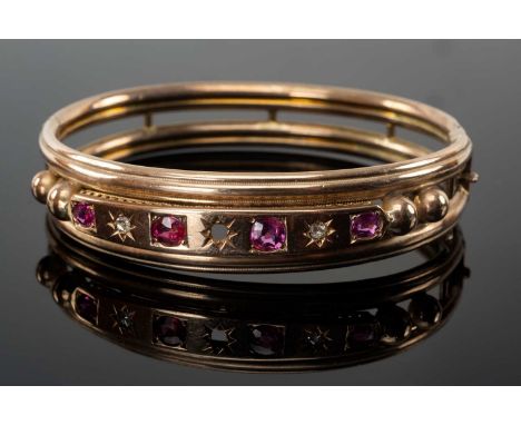 VICTORIAN YELLOW GOLD BANGLE set with graduated rubies and diamond chips, unmarked, 16.0gmsProvenance: private collection Den