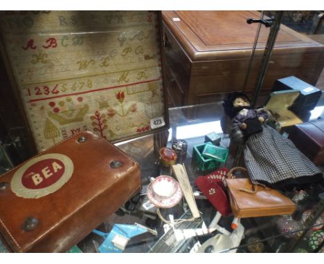 A needlework sampler, costume doll, miniature Spode cup and saucer, dolls suitcase and other collectables 