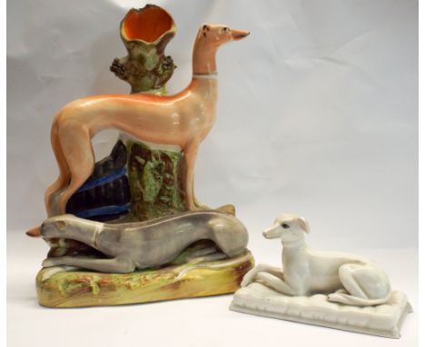 A Staffordshire greyhound taper stand and a small white greyhound ornament      Chip to bottom edge of smaller greyhound. Som
