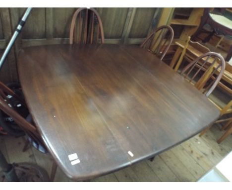 Dark Ercol drop leaf table with four stick back chairs 