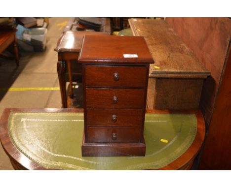 A mahogany trinket chest fitted four drawers and raised on platform plinth