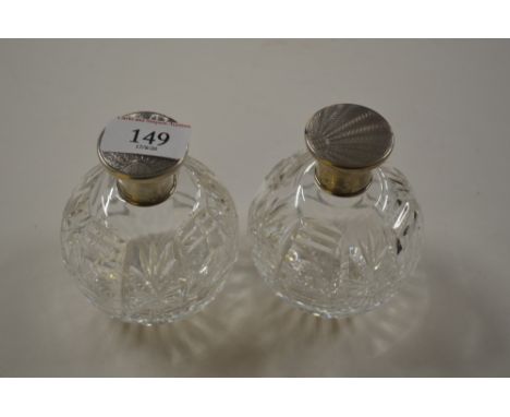 A pair of Art Deco cut glass scent bottles with silver mounts and engine turned decoration