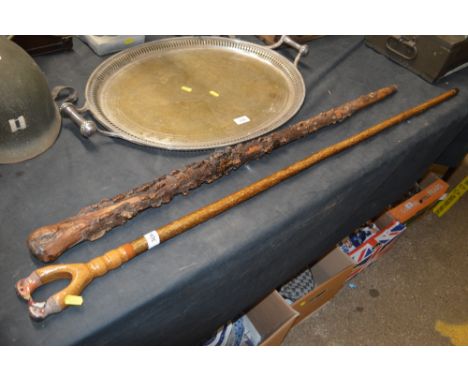 A wooden walking stick the handle in the form of two painted bird's heads and a narled walking stick