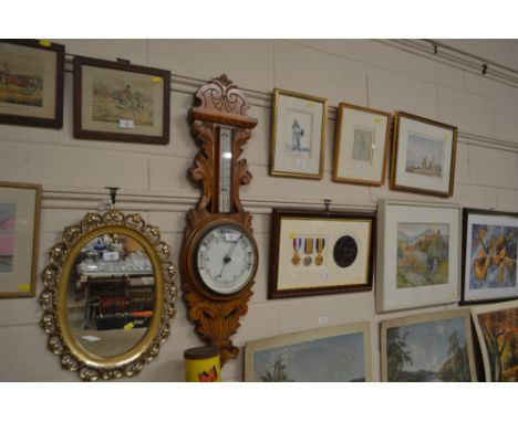 An early 20th Century golden oak cased aneroid barometer 