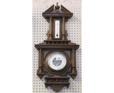 An aneroid wall barometer in carved walnut case with enamelled thermometer scale.