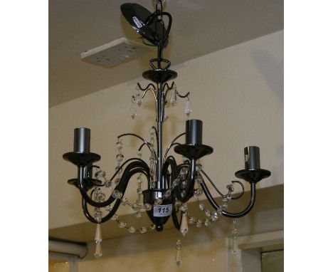 A metal five branch chandelier with glass droplets along with a Gothic style wall mirror.