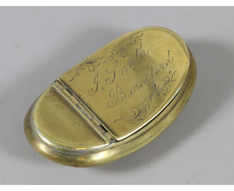 A Georgian brass snuff box of ovoid concave form engraved with foliate scrolls and inscribed J. Smith Beresford.