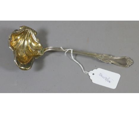 A Swedish silver ladle with reeded handle and gilded shell shaped bowl.